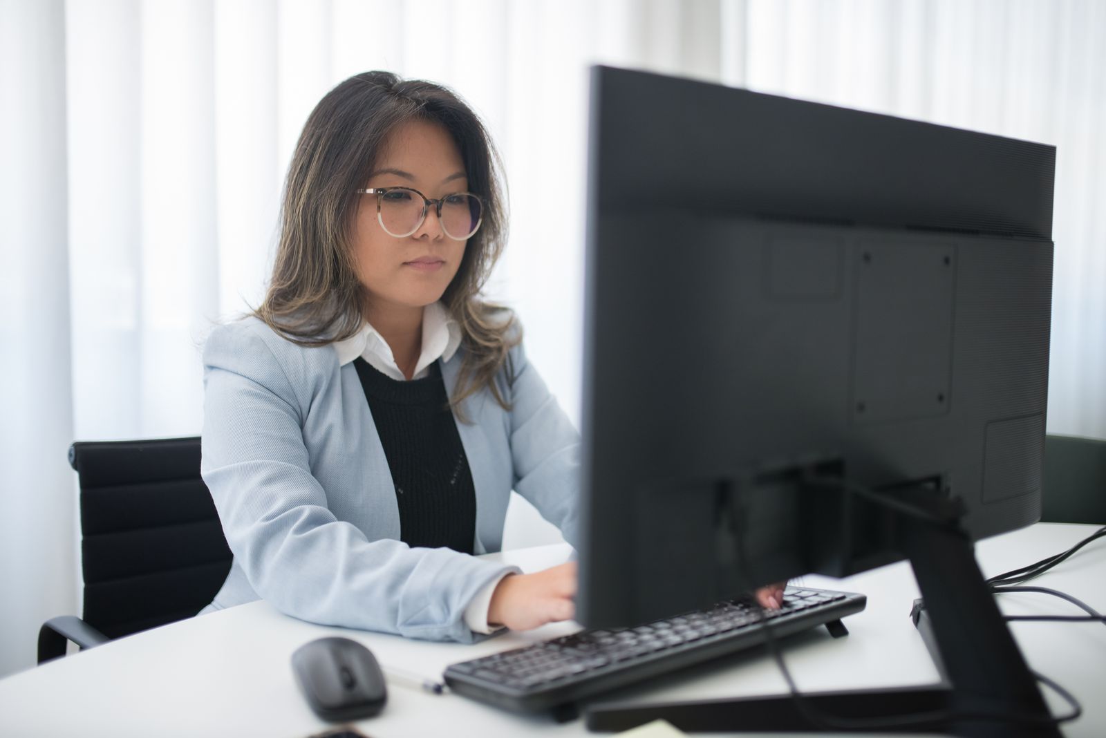 Business analyst working on computer analyzing data in modern office
