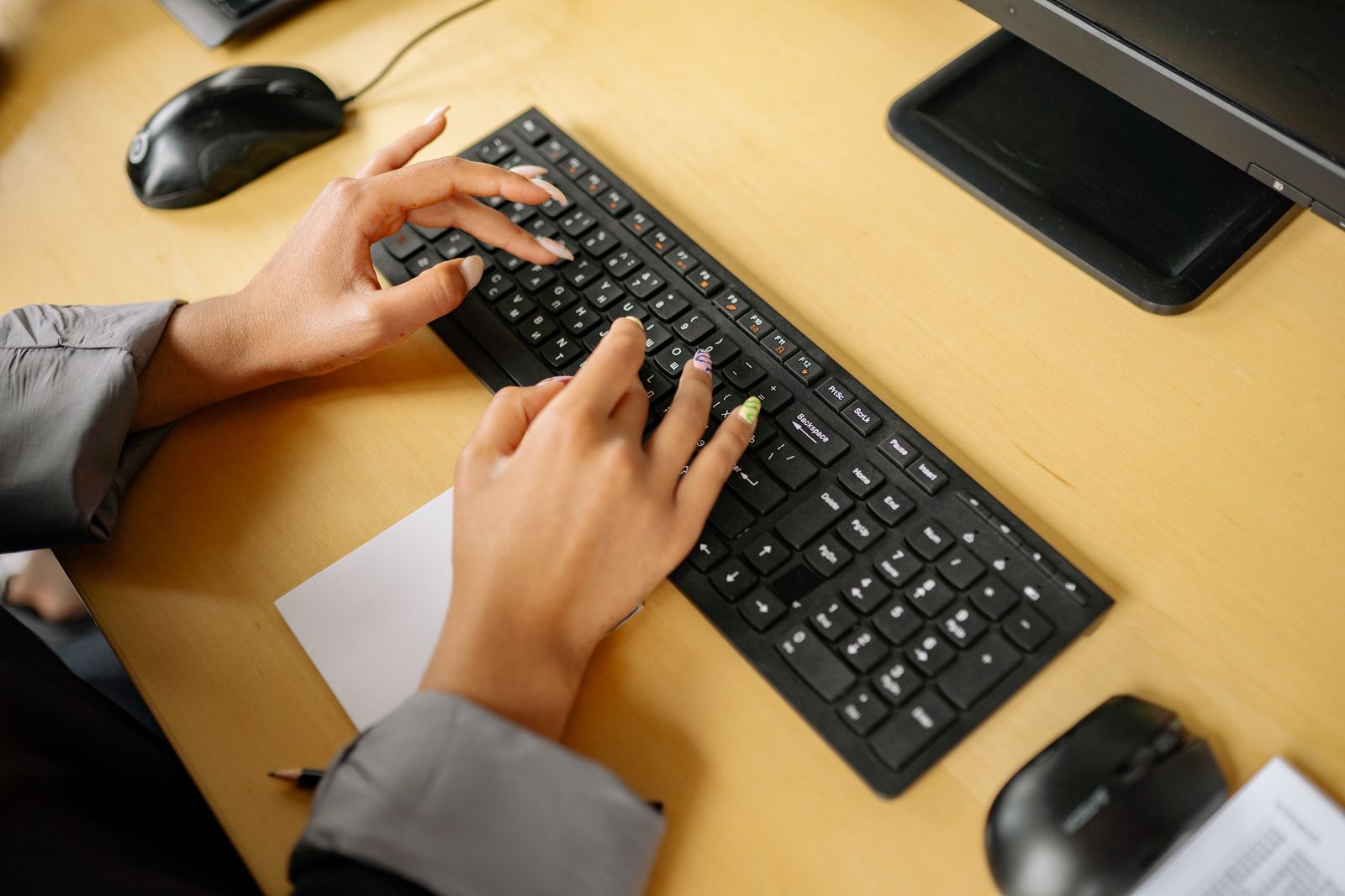 Close-up of hands typing on keyboard in finance office environment