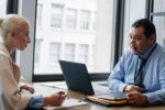 Interviewer and job applicant discussing HR interview questions in an office