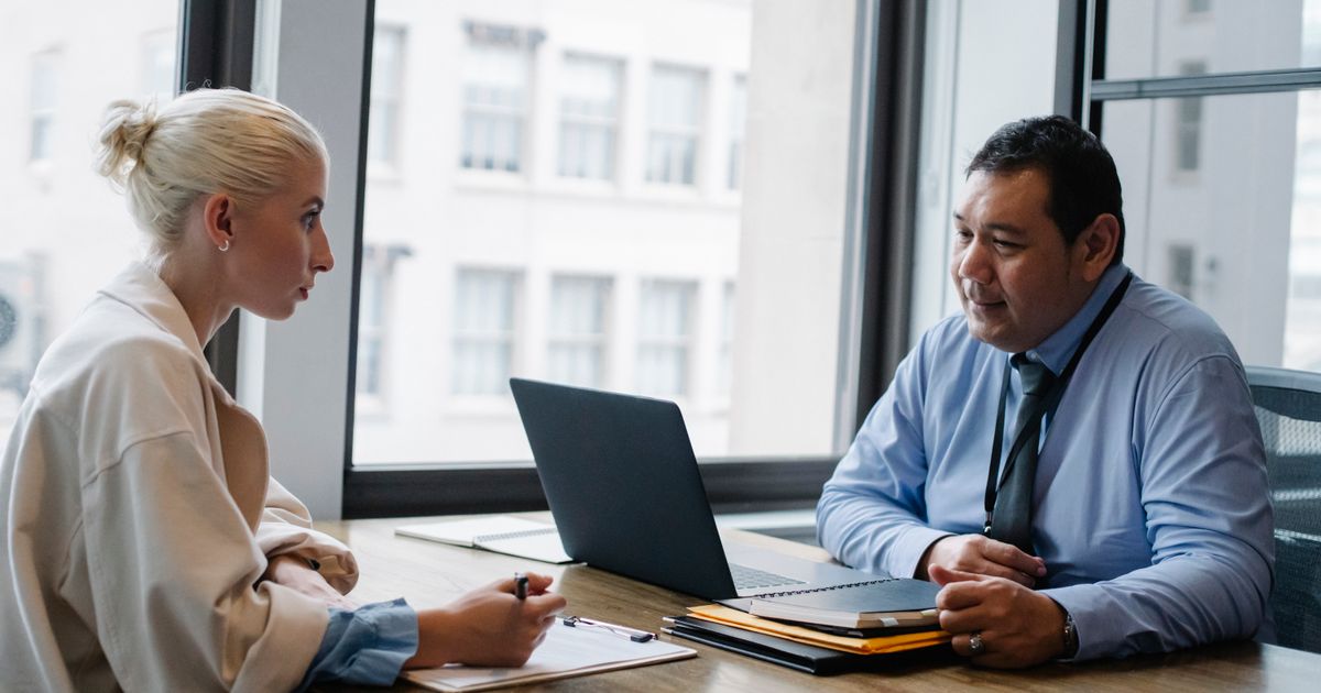 Interviewer and job applicant discussing HR interview questions in an office