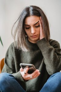 Job seeker looking concerned while checking a message on her phone