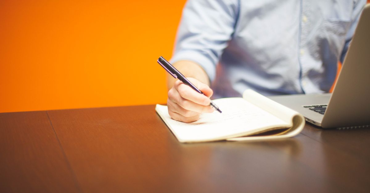 Professional writing a clear email at a laptop workspace