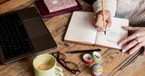 Person writing notes at a desk while planning their notice period and job transition