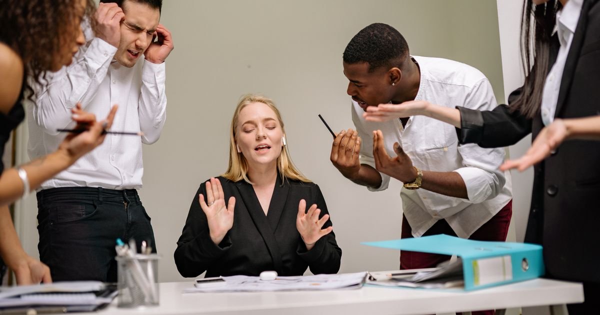 Team having a conversation in an office, representing career transitions and job hopping decisions