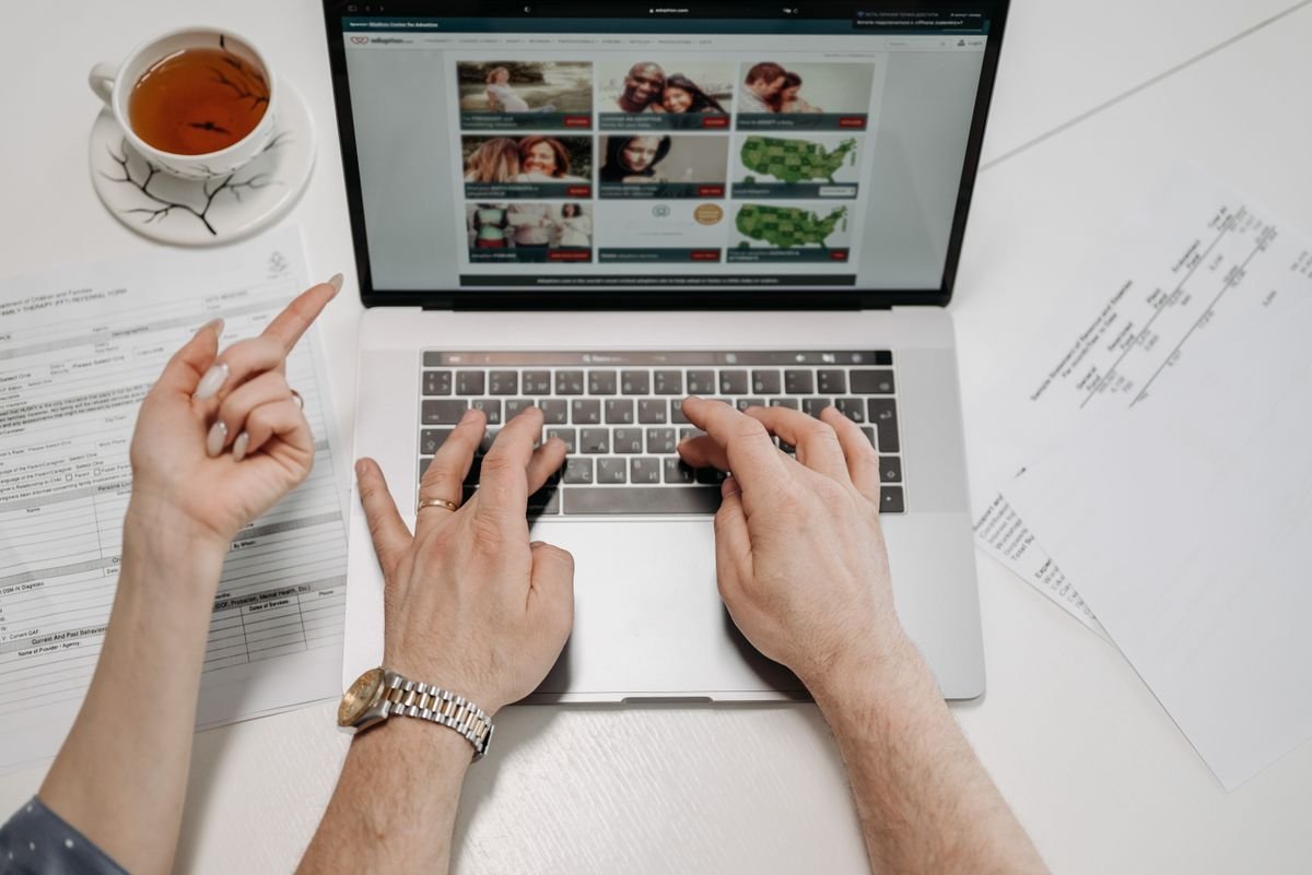 Close-up of hands typing on a laptop keyboard
