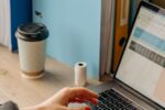 Professional writing an email at their office desk