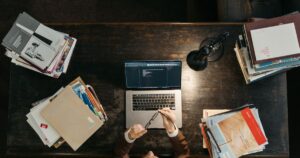 Student preparing for an aptitude test with books and laptop at a desk